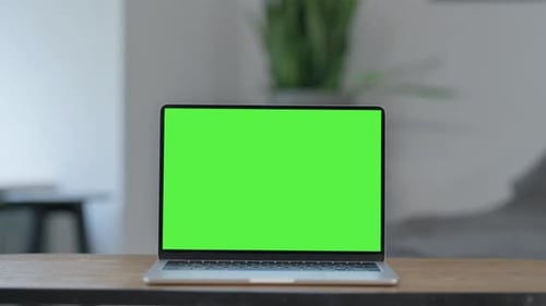 Laptop with Green Screen on Desk at Home