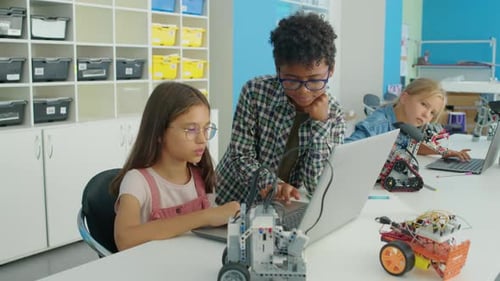 Diverse Kids Working Together on Program for Electric Robot at Hobby Club