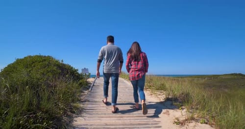 Couple Walking Along Sand Towards Beach Ocean Sunny Day America