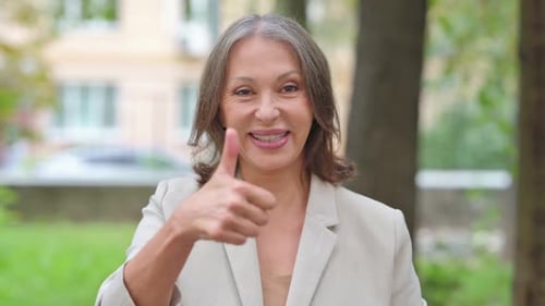 Woman Giving Thumbs Up Outdoors