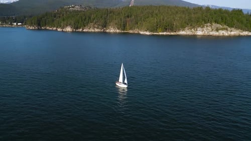 Luftaufnahme eines Bootes, das bei Sonnenuntergang entlang der Küste segelt