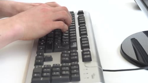 Man typing on computer keyboard.