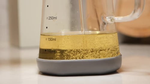Close up glass jar with clear yellow liquid