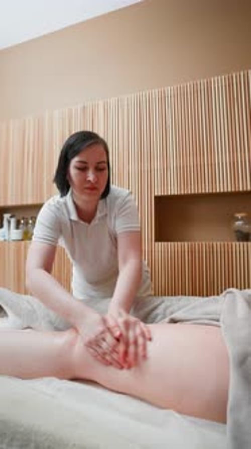 Massage Therapist Giving Leg Massage in Spa
