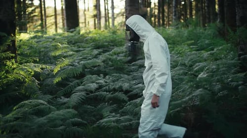 Mann mit Kontamination Weißer Anzug und Gasmaske geht in den Bergen spazieren