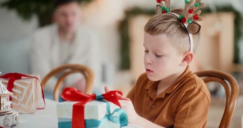 Excited Boy Unwraps Christmas Gift at Home