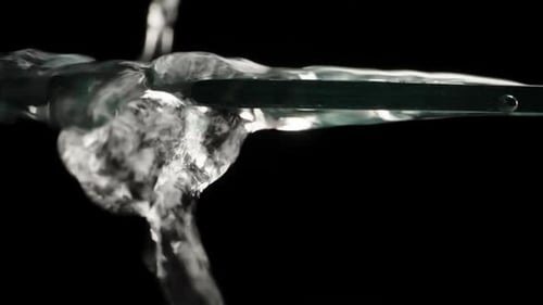 Clear Water Pouring onto Transparent Surface in Dark