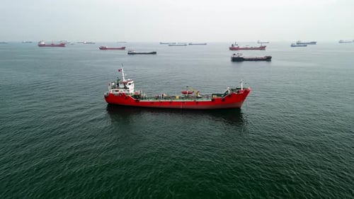Flyback drone shot of a transport ship in the sea