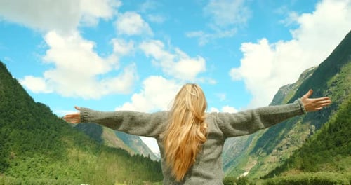 Woman Enjoys Mountain View with Arms Raised