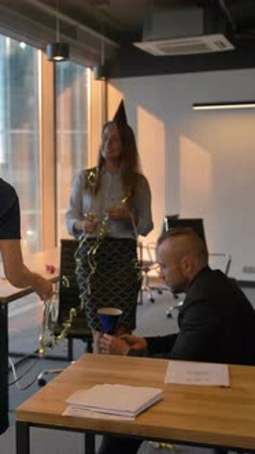 Vertical de colegas atraentes e bonitos comemorando o aniversário do chefe no escritório