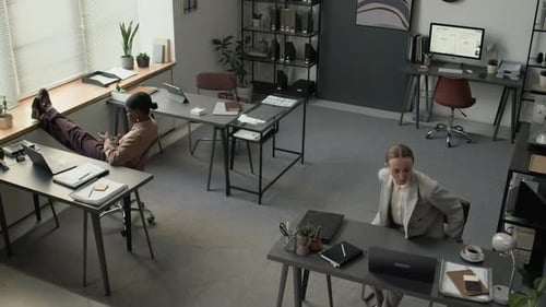 Femmes d'affaires travaillant avec désinvolture sur des ordinateurs dans un espace de travail ouvert dans un bureau moderne