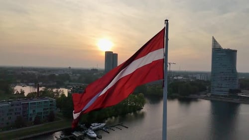 Flag Waving Over City at Sunrise