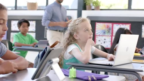 Caucasian girl in a school classroom with a laptop