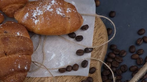 Fresh Croissants with Coffee Beans on a Wooden Board