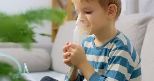 Blond Boy Using Nebulizer Mask for Respiratory Treatment