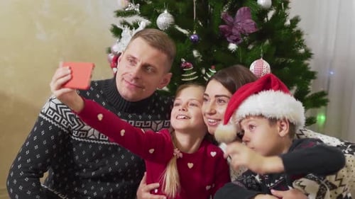 Family Takes a Selfie in Front of Christmas Tree