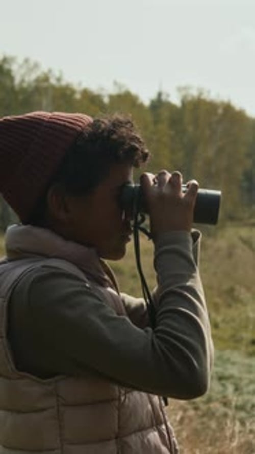 Young Explorer Observing Nature with Binoculars