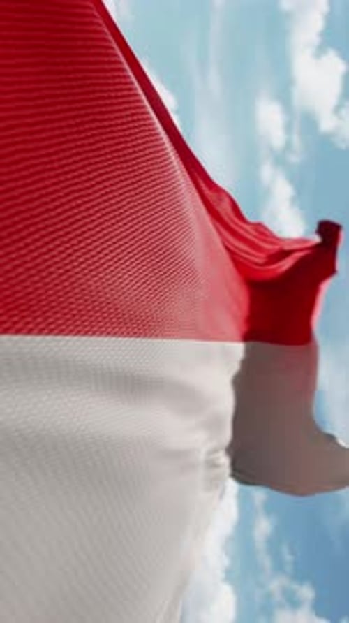 Red and White Flag Waving Against Blue Sky