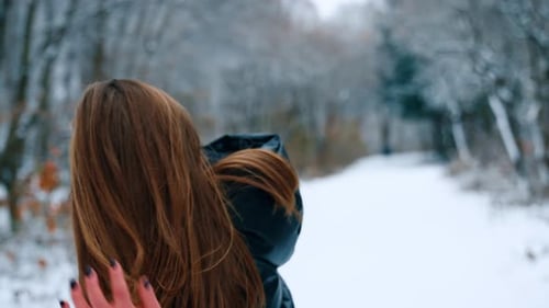 Woman Walking in a Snow-Covered Winter Park