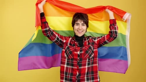 Smiling Person Holding a Rainbow Pride Flag