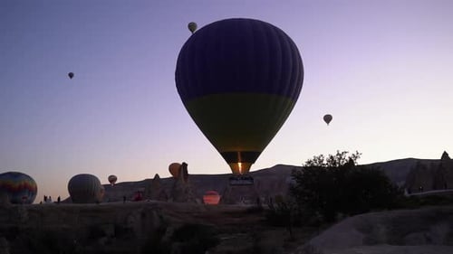 Slow motion of a flame shooting into a rising hot air balloon at dawn in Cappadocia Turkey