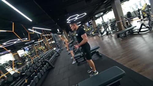 Sportive fit people using dumbbells for their training in modern gym