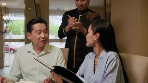 Couple Asking Waiter about Menu in Restaurant