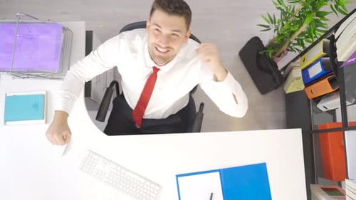 Man at Desk Celebrates Success