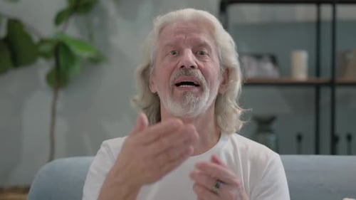 Senior Man Talking to Camera in Living Room