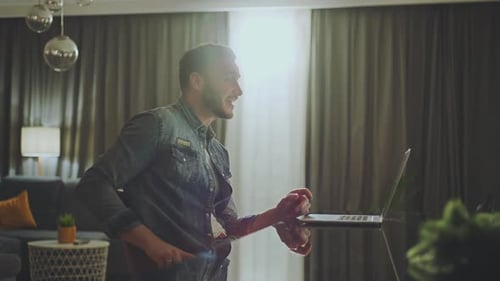 Man Works on Laptop During Video Call at Home