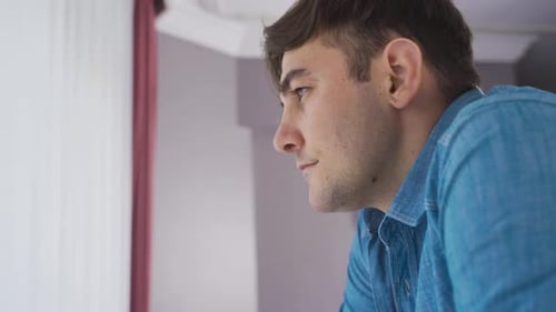 Unhappy young man is alone at home.