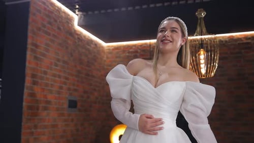 Retrato de uma linda noiva feliz experimentando um vestido de noiva em um salão de casamento