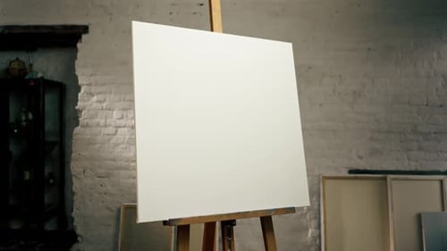 Close Up in an Art Studio There is a Tripod with a Large White and Blank Canvas Next to a Box