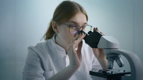 Female Scientist Using Microscope in Lab