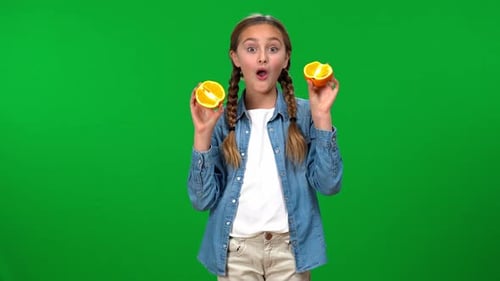 Girl Posing with Orange Halves Against Green Screen