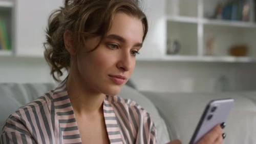 Woman Using Smartphone Device in Home Living Room