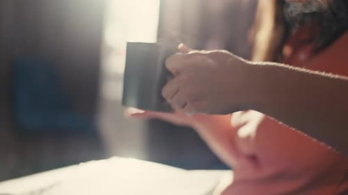Caucasian Woman Typing on a Computer Keyboard Takes a Cup of Coffee