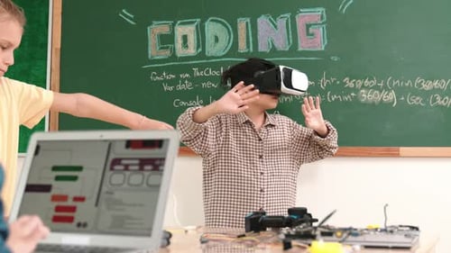 Junge mit VR-Headset, um die Metawelt zu betreten, während Mädchen das System codieren. Pädagogik.