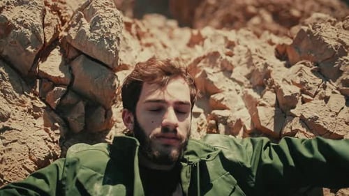Man Lying on Rocks in Desert Landscape