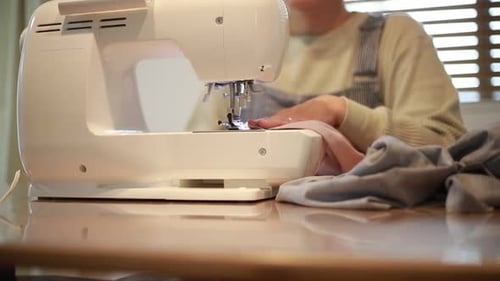 Woman Sewing Fabric With a Modern Sewing Machine