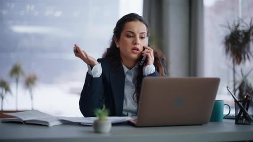 Woman talking angrily on phone in the office