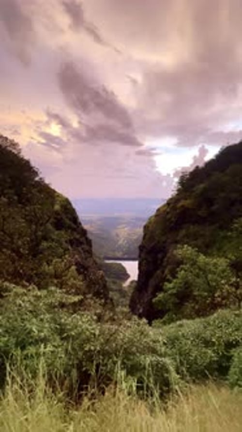 Le lac de Bhandardhara au milieu de montagnes luxuriantes sous un ciel nuageux spectaculaire Maharashtra