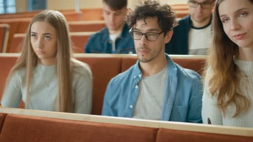 Reihe multiethnischer Schüler im Klassenzimmer, die Prüfung/Testen/Schreiben in Notizbücher ablegen. Strahlend jung