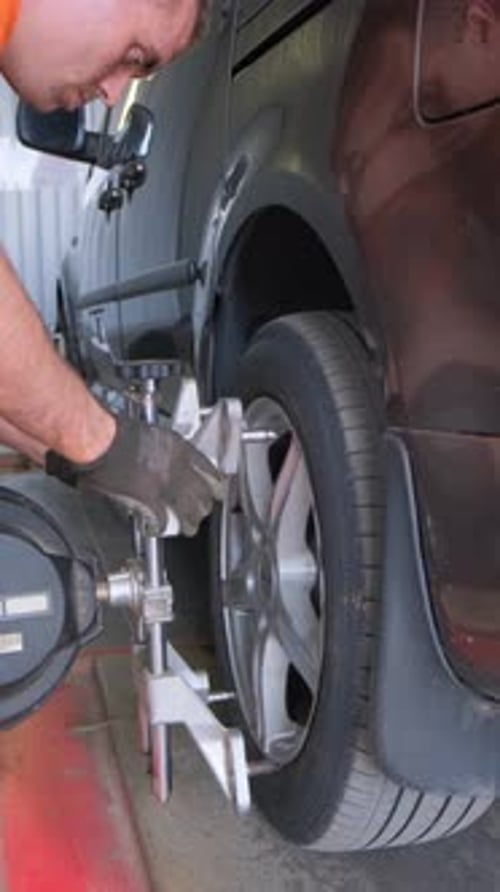 Ein Automechaniker verursacht einen Sturz in einem Auto, Karosseriereparatur, Autoservice, Vertikales Video