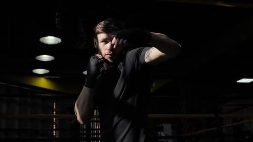 Man Throwing Punches in Boxing Ring