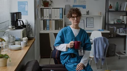 Young Adult in Scrubs Holding Coffee Mug