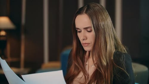 Serious Businesswoman Reading Paper Documents In Office. Portrait Of Focused Woman Looking Financ...