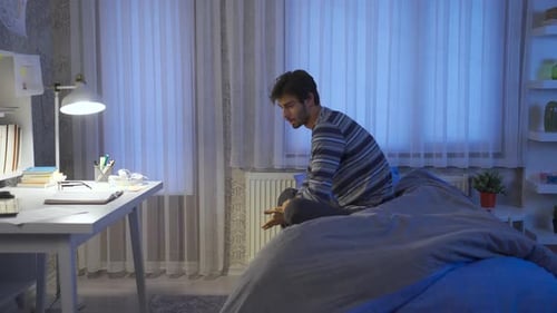 Unhappy and thoughtful young man not sleeping at night.