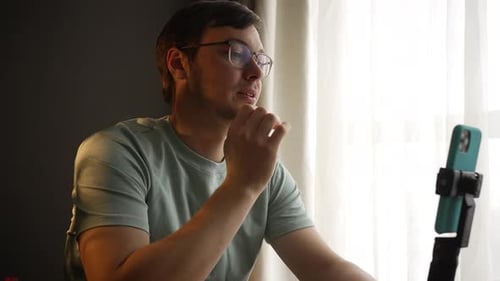 Young Man Talking to a Phone Indoors