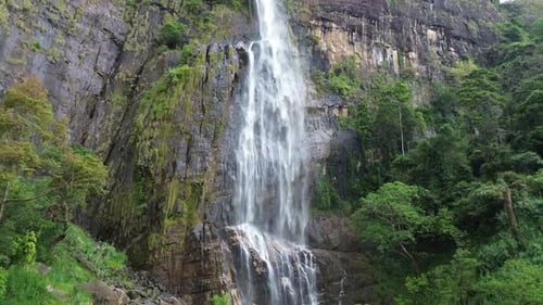 Majestic Waterfall Cascading Down Rocky Cliffside in Jungle